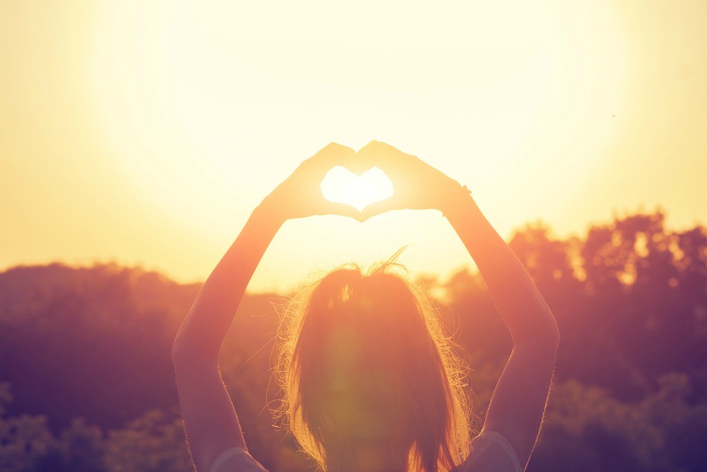 Heart-shape for the nature - young girl making a heart symbol.